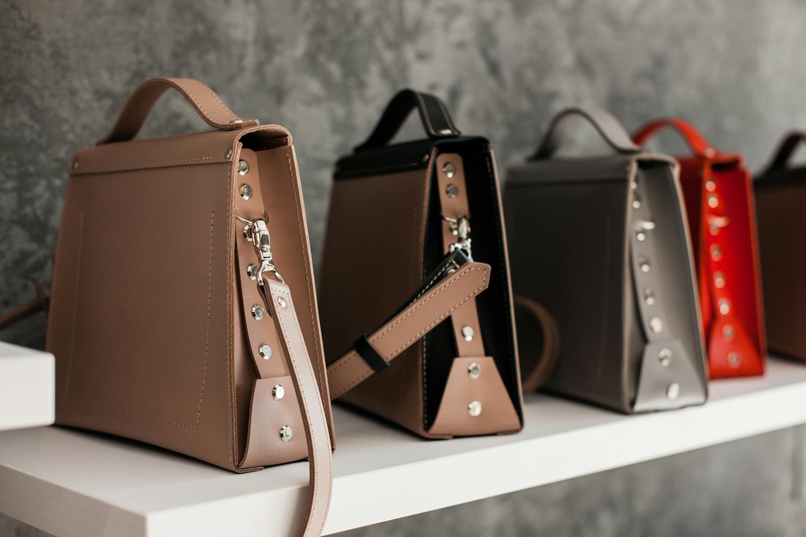 Finished leather handbags displayed on a shelf