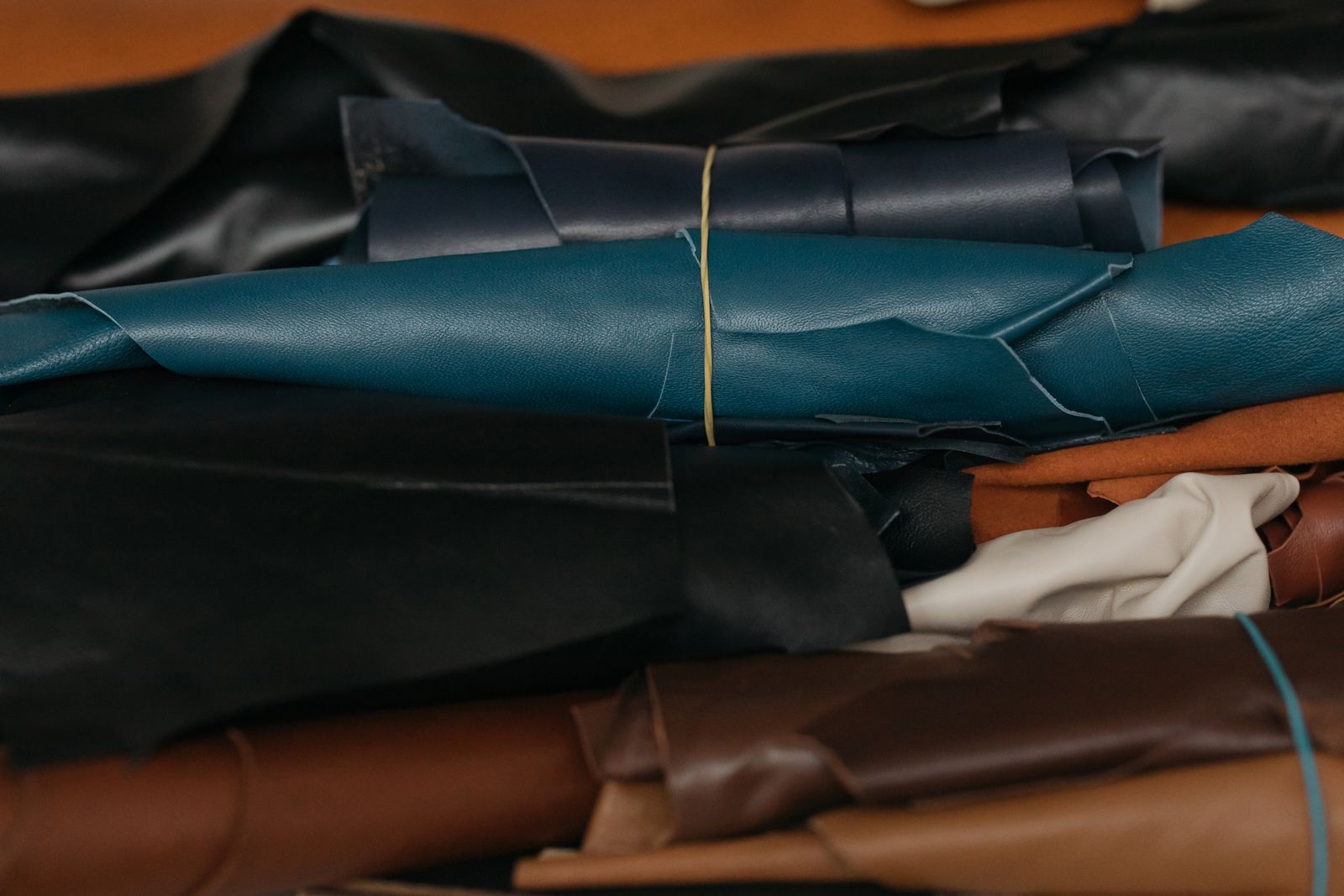 Stacked rolls of top-grain leather in tannery colours